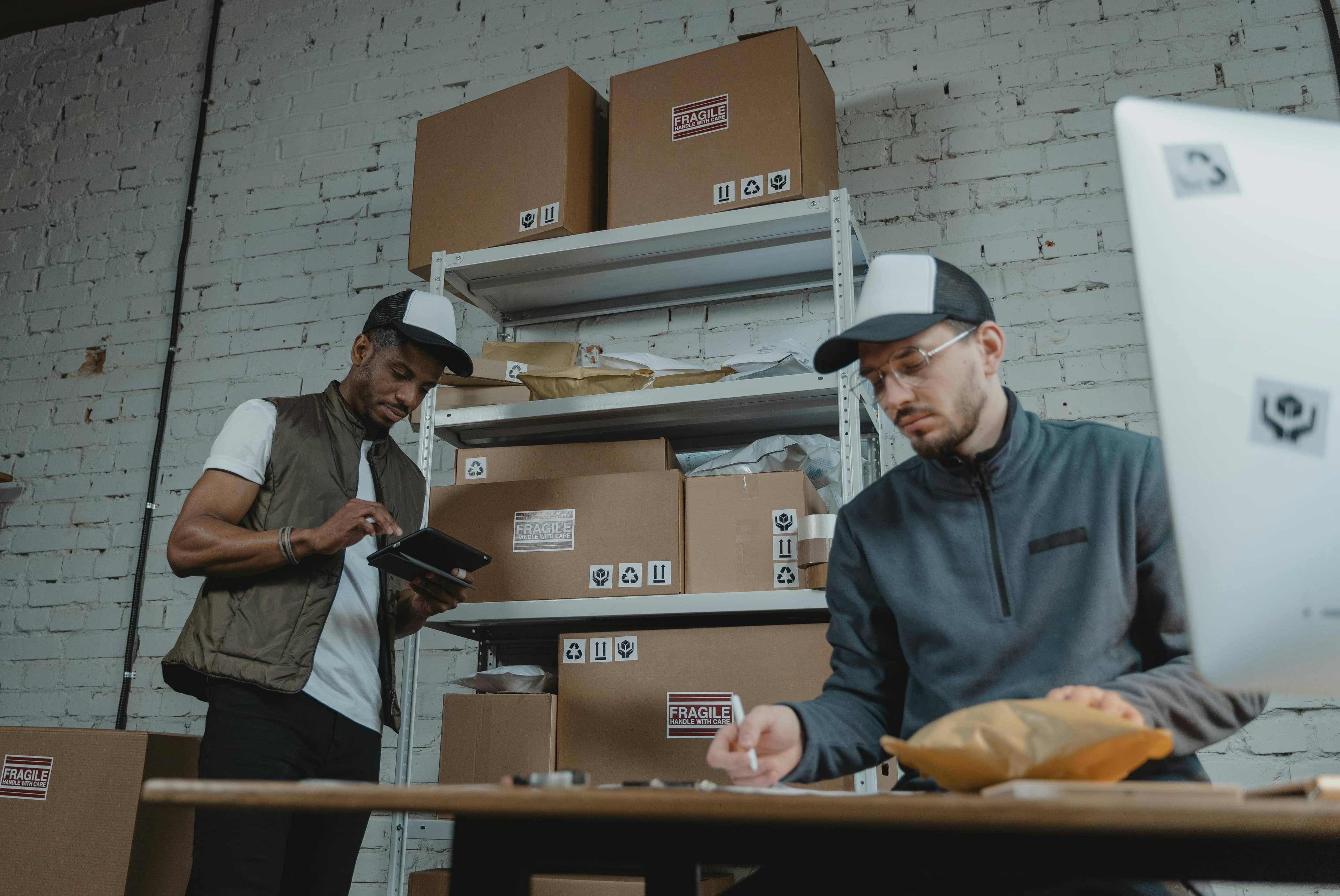 Two couriers preparing parcels at the depot