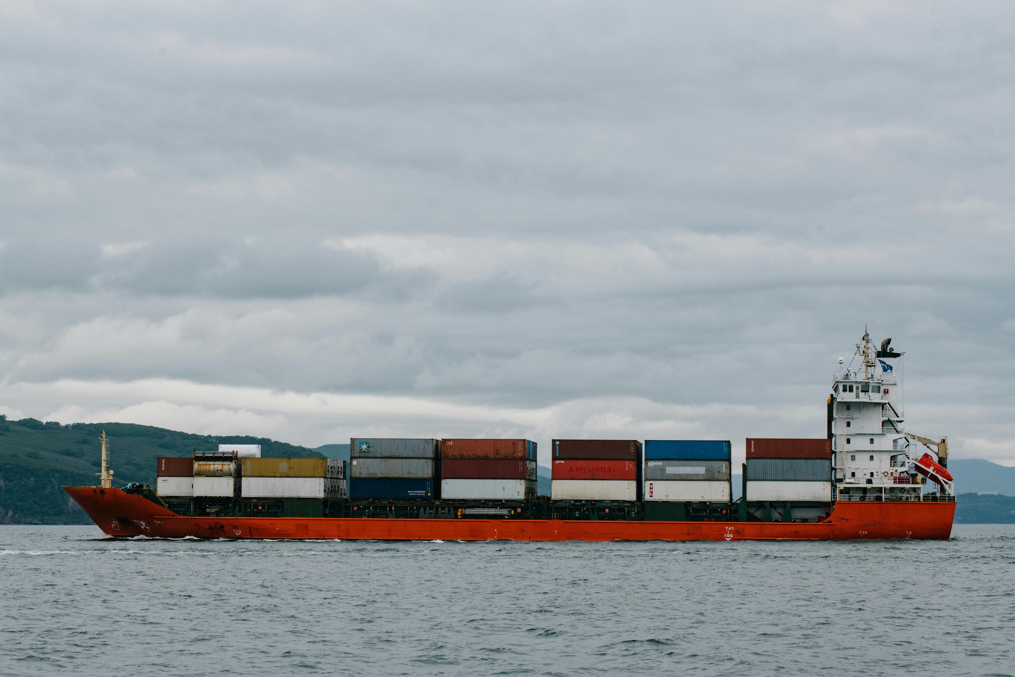 A loaded container ship under way along the coast