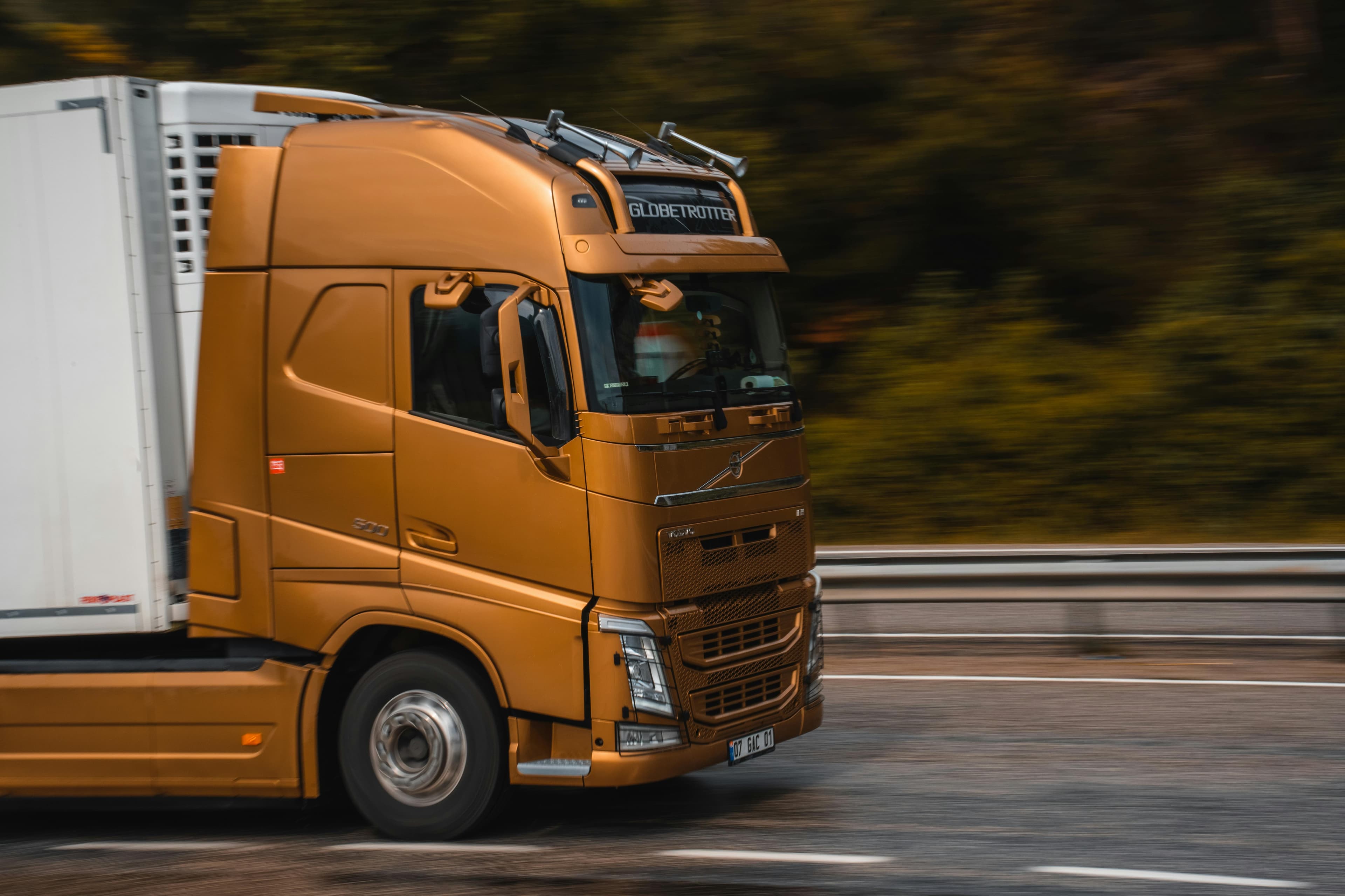 A tractor-trailer moving fast along a highway
