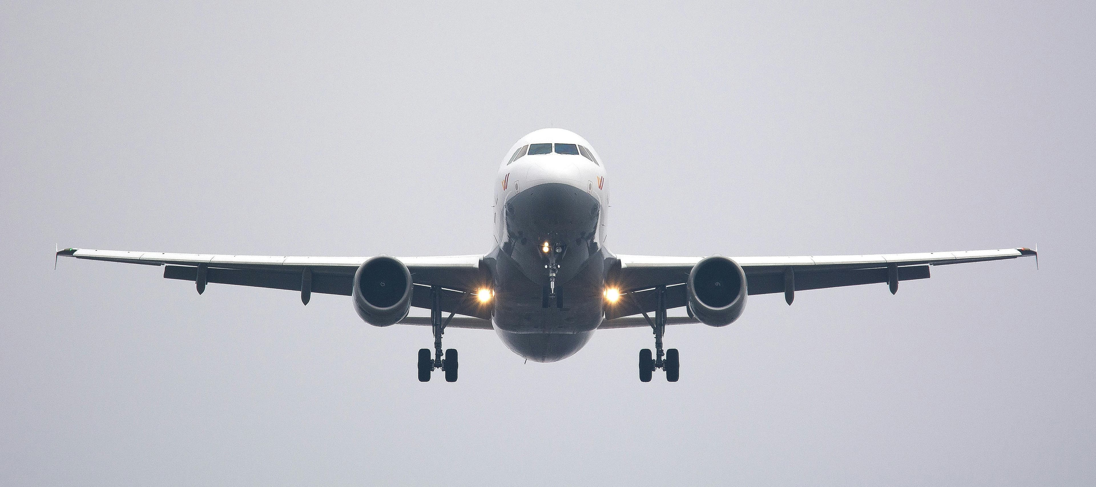 A jet on final approach with its landing lights on